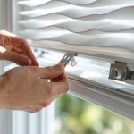 Person removing corded blinds from window bracket using proper lifting technique