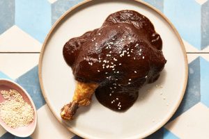 A dark, textured pile of dried Chilhuacle Negro chiles, a key rare ingredient for Oaxacan mole negro.