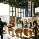 Visitors exploring modern furniture and design exhibits inside The Barker Hangar at WestEdge Design Fair 2026 in Santa Monica.