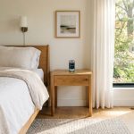 Modern wooden nightstand with built-in charging pad in a clean bedroom.