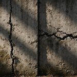 Foundation wall split showing a vertical crack on one side and a horizontal crack on the other